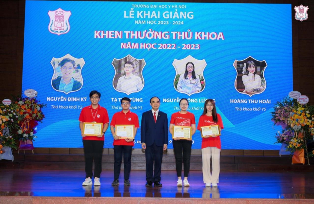 A group of people standing on a stage with awards

Description automatically generated